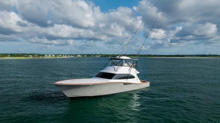 Slide: The Image of 2024 Matthews 62 Sport Fish yacht cruising on open water under a partly cloudy sky. - 2