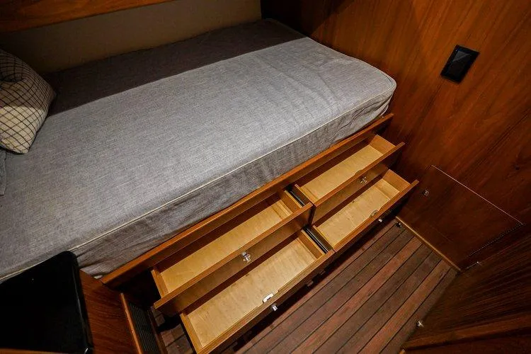 Slide: The Image of 2024 Matthews 62 Sport Fish cabin with bed and open storage drawers. - 21