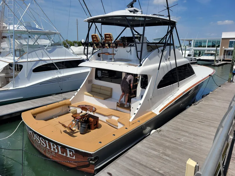 Slide: The Image of 2024 Matthews 62 Sport Fish yacht docked at marina, featuring spacious deck and modern design. - 25