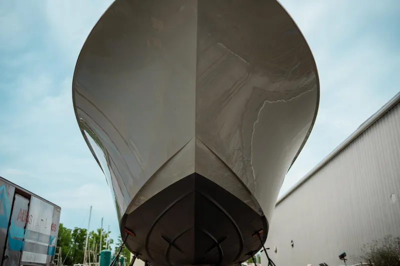 Slide: The Image of 2024 Matthews 62 Sport Fish boat hull, docked outdoors, viewed from the front. - 30