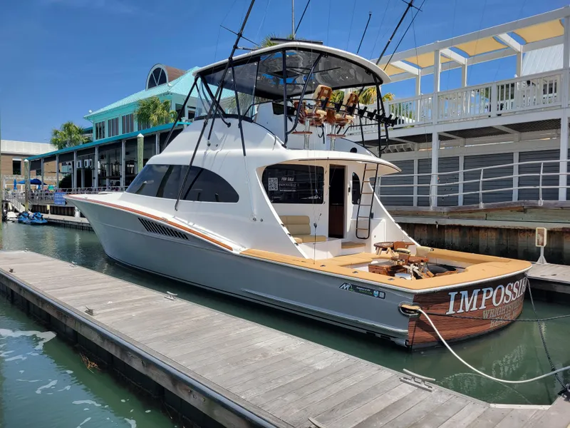 Slide: The Image of 2024 Matthews 62 Sport Fish yacht docked at marina, featuring sleek design and fishing equipment. - 4