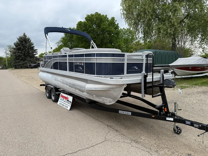 Slide: The Image of 2021 Bennington 22 SSR pontoon boat on a trailer, parked on a street. - 1