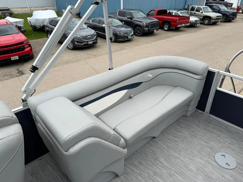 Slide: The Image of 2021 Bennington 22 SSR pontoon boat with gray seating, parked near various vehicles. - 20
