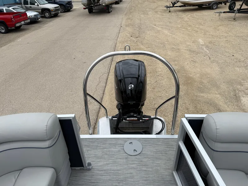 Slide: The Image of 2021 Bennington 22 SSR pontoon boat with outboard motor, parked on a gravel lot. - 22
