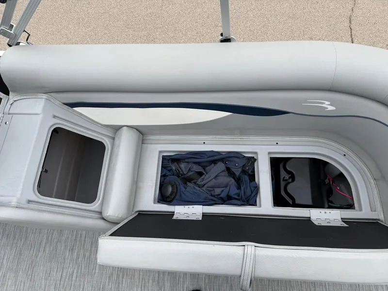 Slide: The Image of 2021 Bennington 22 SSR boat interior storage compartments with open seats and visible gear. - 23
