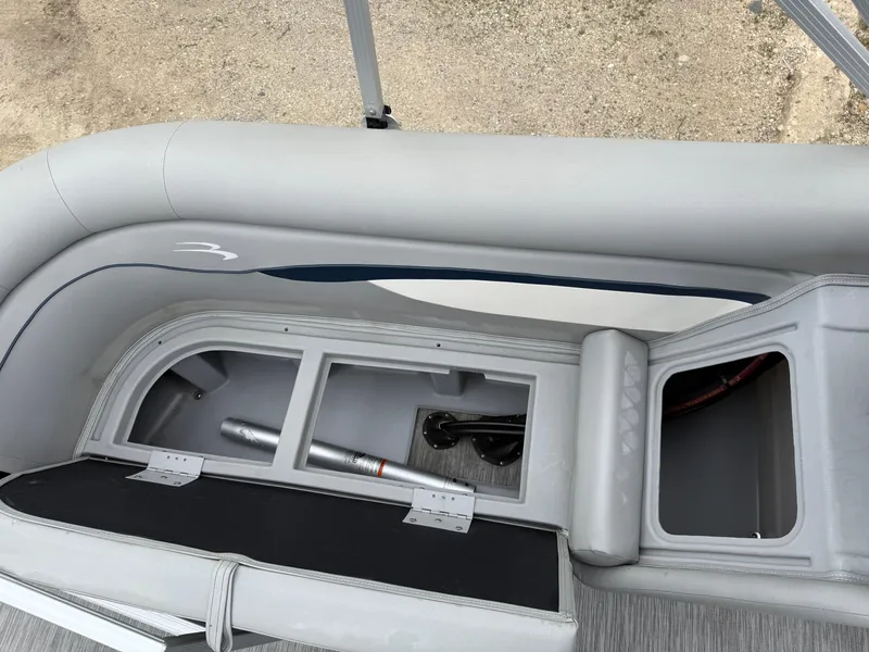 Slide: The Image of 2021 Bennington 22 SSR boat interior storage compartments with gray seating and sleek design. - 24