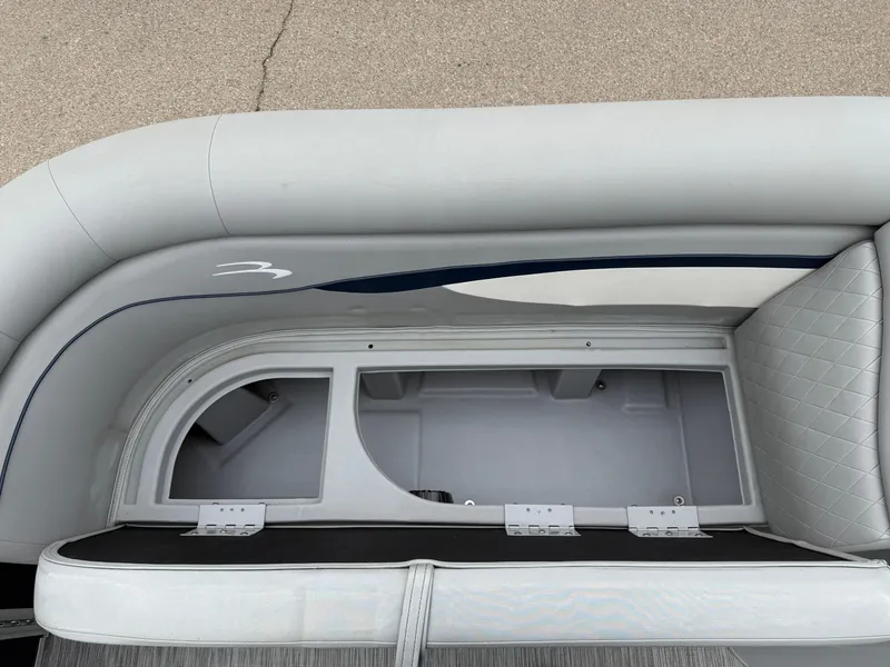 Slide: The Image of 2021 Bennington 22 SSR boat storage compartment with cushioned seating and sleek design. - 26