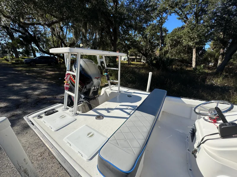 Slide: The Image of 2006 Key Largo 174 boat with seating and steering, parked outdoors under trees. - 10
