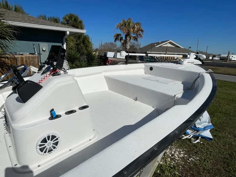 Slide: The Image of 2006 Key Largo 174 boat with open deck, steering console, and seating, parked outdoors. - 12