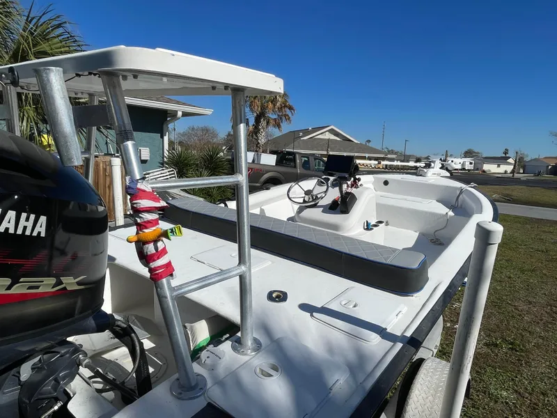 Slide: The Image of 2006 Key Largo 174 boat with Yamaha engine, parked outdoors under clear blue sky. - 13