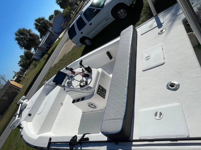 Slide: The Image of 2006 Key Largo 174 boat interior with steering console and seating, parked near a white vehicle. - 16