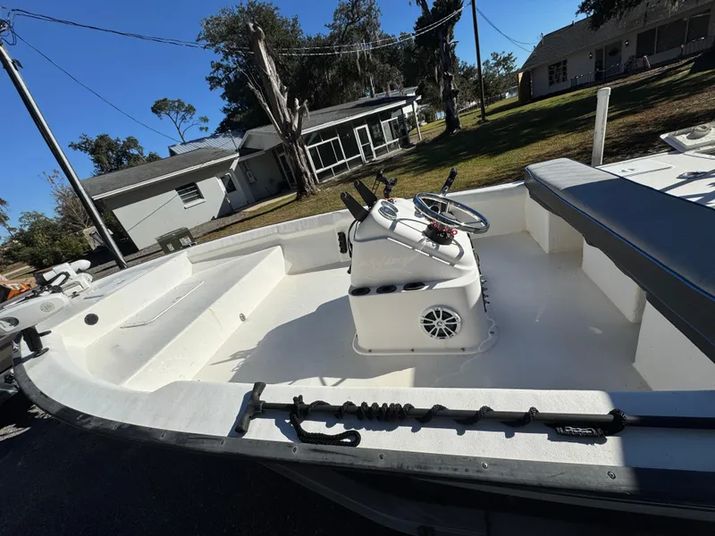 Slide: The Image of 2006 Key Largo 174 boat with center console, parked outdoors near residential area. - 4