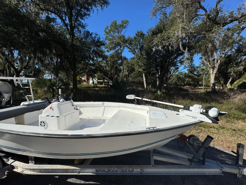 Slide: The Image of 2006 Key Largo 174 boat on trailer, parked outdoors under trees. - 8