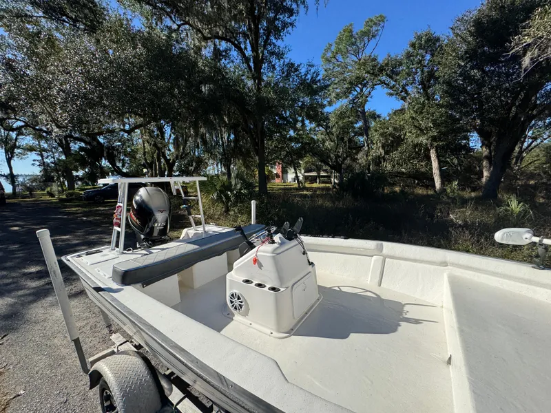 Slide: The Image of 2006 Key Largo 174 boat on trailer, surrounded by trees and clear blue sky. - 9