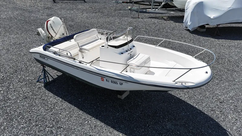 Slide: The Image of 2001 Boston Whaler DAUNTLESS boat on gravel, side view, with outboard motor. - 11