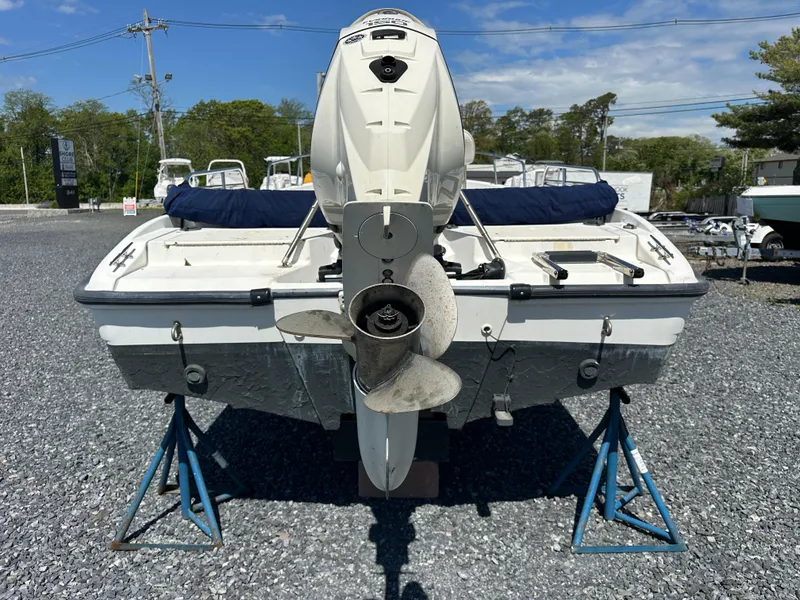 Slide: The Image of 2001 Boston Whaler DAUNTLESS boat on stands, rear view with outboard motor. - 12