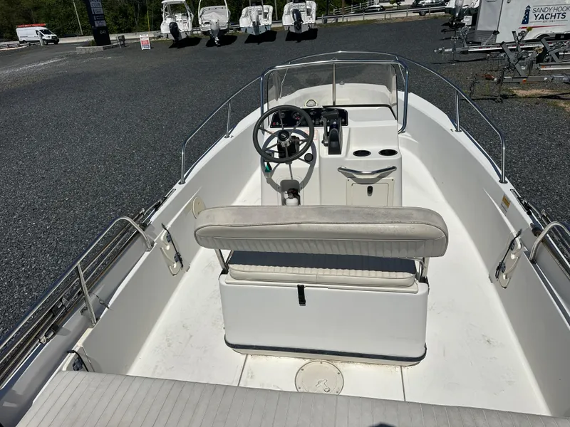 Slide: The Image of 2001 Boston Whaler DAUNTLESS boat interior with steering wheel and seating, parked on gravel. - 15