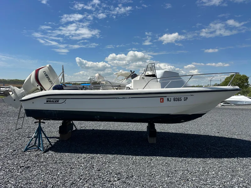 Slide: The Image of 2001 Boston Whaler DAUNTLESS boat on stands, clear sky background. - 16