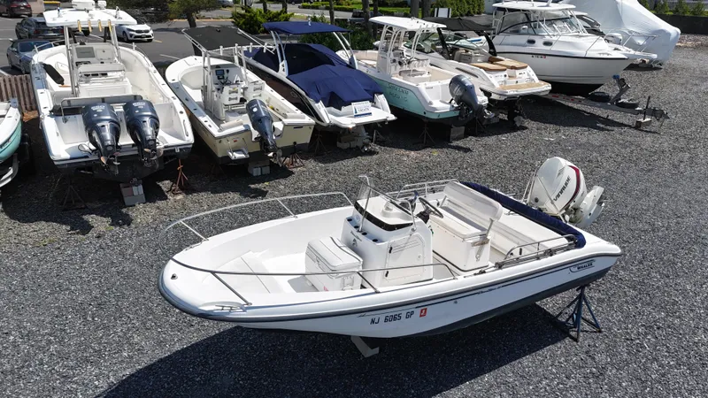 Slide: The Image of 2001 Boston Whaler DAUNTLESS boat on gravel lot, surrounded by other boats. - 3