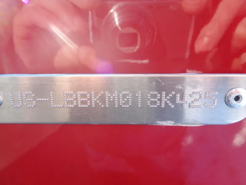 Slide: The Image of 2025 Lund 1875 Impact XS SS boat identification plate on red background. - 16