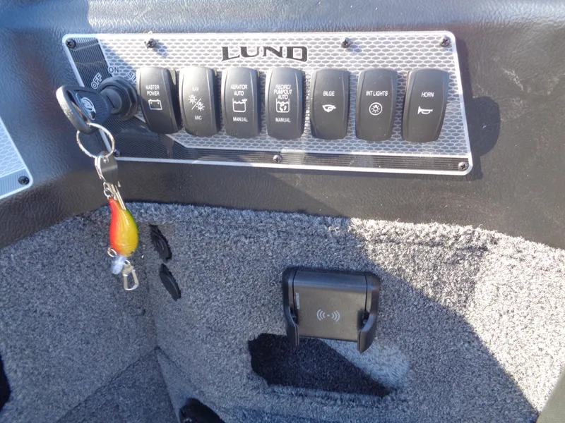 Slide: The Image of Control panel of 2025 Lund 1875 Impact XS SS boat with key and switches. - 27