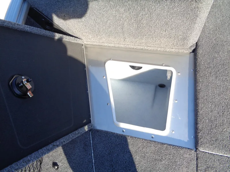 Slide: The Image of 2025 Lund 1875 Impact XS SS boat storage compartment with open hatch, showing interior space. - 32