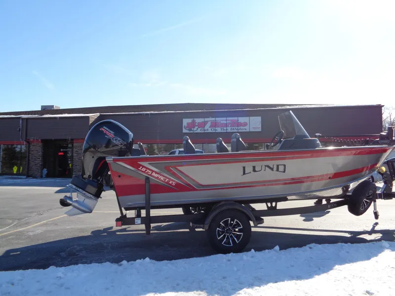 Slide: The Image of 2025 Lund 1875 Impact XS SS boat on trailer, parked in snowy lot. - 6