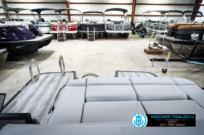 Slide: The Image of 2025 Bennington 24 MSB pontoon boats in showroom, featuring sleek design and comfortable seating. - 18