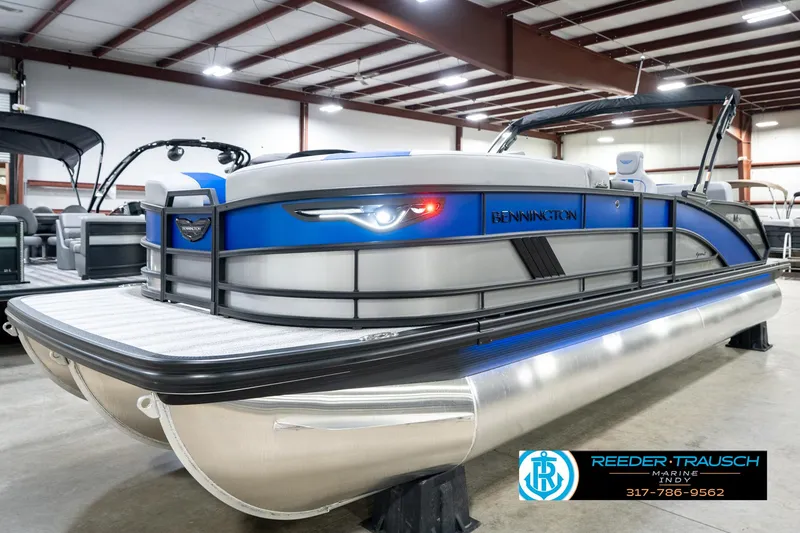 Slide: The Image of 2025 Bennington 24 MSB pontoon boat in showroom, featuring sleek design and modern amenities. - 2
