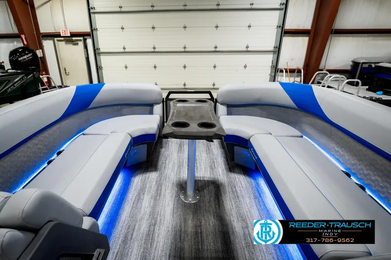 Slide: The Image of 2025 Bennington 24 MSB pontoon boat interior with blue LED lighting and plush seating. - 23