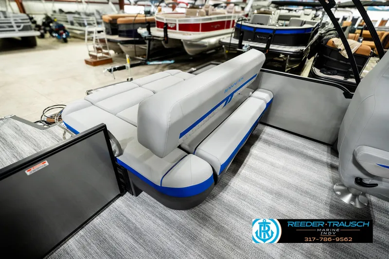 Slide: The Image of 2025 Bennington 24 MSB pontoon boat interior with gray seating and blue accents in showroom. - 27