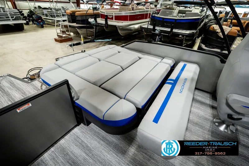 Slide: The Image of 2025 Bennington 24 MSB pontoon boat interior with plush seating in a showroom. - 28