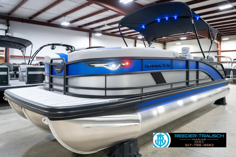 Slide: The Image of 2025 Bennington 24 MSB pontoon boat with blue accents in a showroom. - 3
