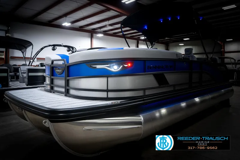 Slide: The Image of 2025 Bennington 24 MSB pontoon boat in showroom with blue accents and LED lights. - 4