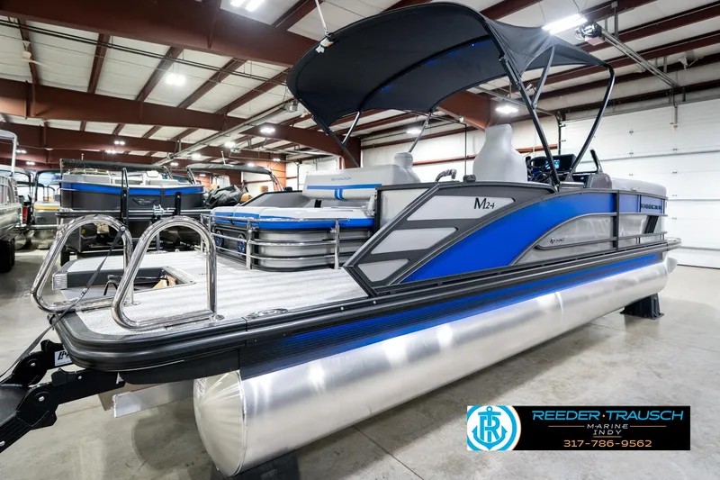 Slide: The Image of 2025 Bennington 24 MSB pontoon boat with blue accents in showroom. - 8