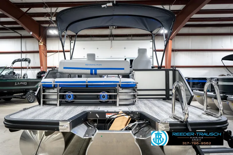 Slide: The Image of 2025 Bennington 24 MSB pontoon boat in showroom, featuring sleek design and modern amenities. - 9