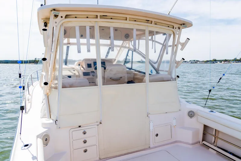 Slide: The Image of 2015 Grady-White 330 Express boat on water, featuring spacious cockpit and enclosed helm. - 8