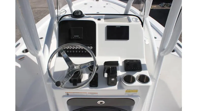Slide: The Image of 2025 Sea Pro 210 boat dashboard with steering wheel, controls, and cup holders. - 13