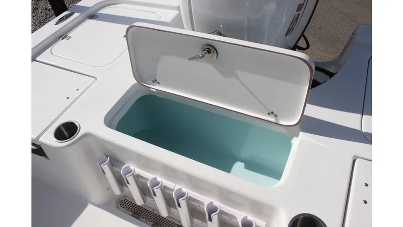 Slide: The Image of 2025 Sea Pro 210 boat with open storage compartment and rod holders. - 6