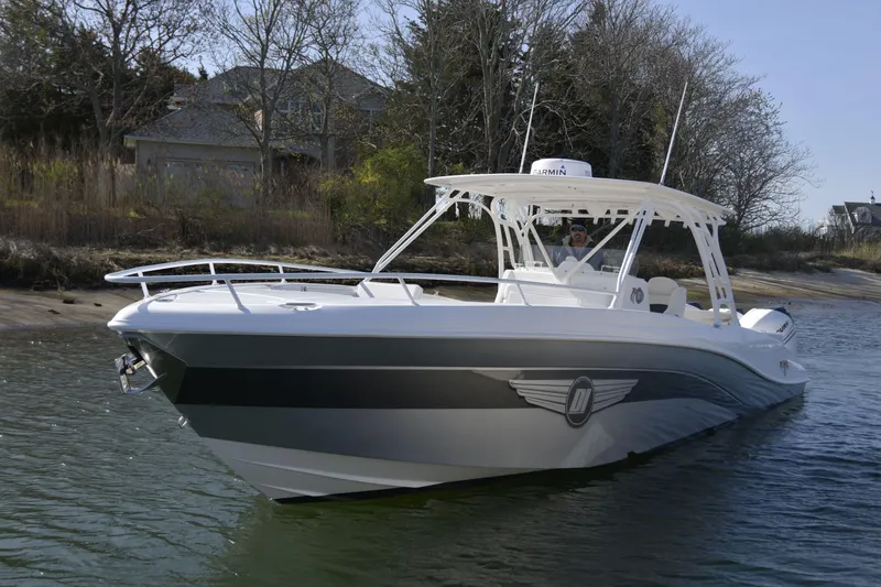 The Image of 2010 Deep Impact 36 TE boat on calm water near a wooded shoreline. - 0