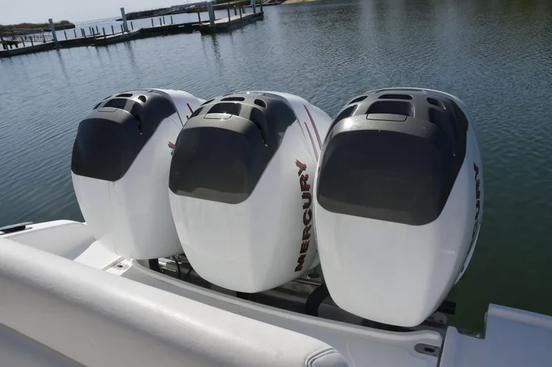 Slide: The Image of Triple Mercury outboard engines on a 2010 Deep Impact 36 TE boat, dockside view. - 21