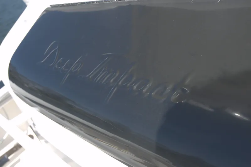 Slide: The Image of 2010 Deep Impact 36 TE boat with engraved logo on dark surface. - 9