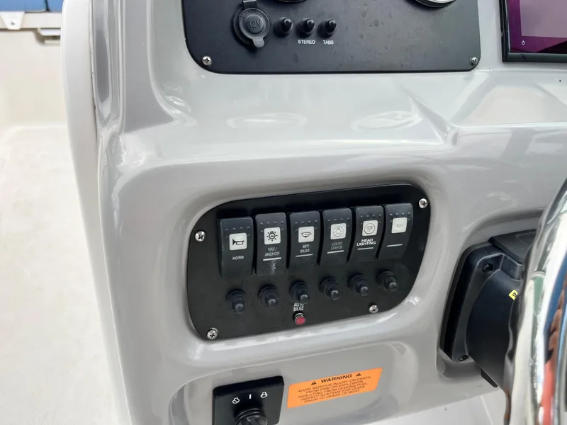 Slide: The Image of 2024 Robalo R207 Dual Console dashboard with control switches and steering wheel. - 15