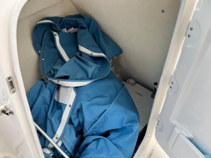 Slide: The Image of 2024 Robalo R207 Dual Console storage compartment with blue cover and equipment. - 21