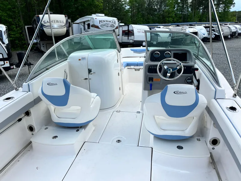 Slide: The Image of 2024 Robalo R207 Dual Console boat interior with white and blue seating, steering wheel, and dashboard. - 7
