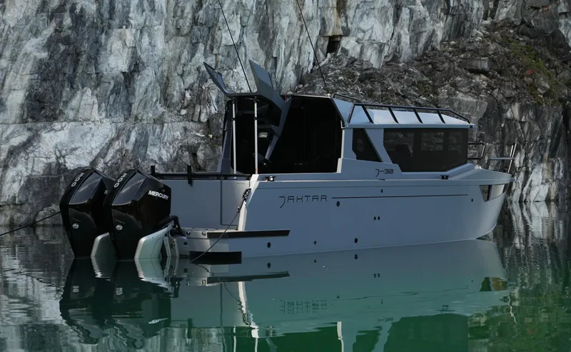Slide: The Image of Jaktar J30 Black Vision 2026 boat on serene water near rocky cliffs. - 12