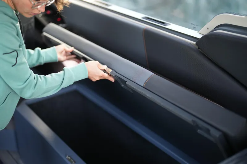 Slide: The Image of Person accessing storage compartment in 2026 Jaktar J30 Black Vision vehicle interior. - 17