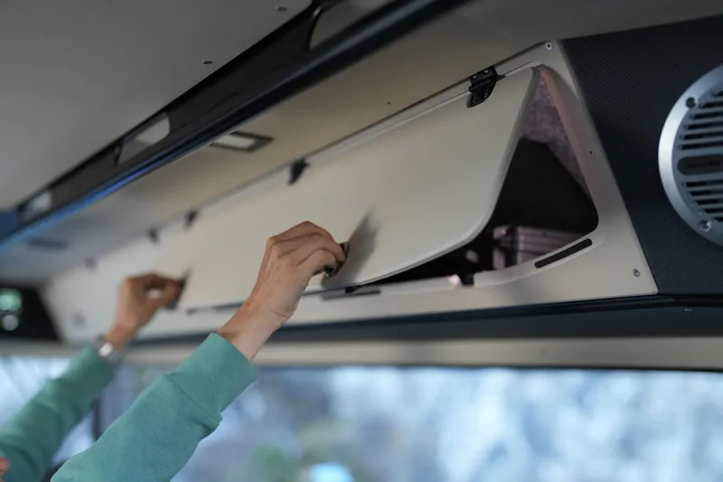 Slide: The Image of Person opening overhead compartment in Jaktar J30 Black Vision, 2026 model. - 19