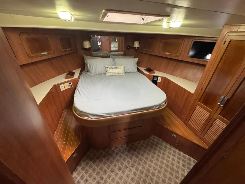Slide: The Image of 1989 Ricker 48 Convertible yacht cabin with wood paneling and cozy bed. - 13