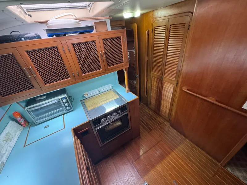 Slide: The Image of 1989 Ricker 48 Convertible yacht kitchen with wooden cabinets and blue countertops. - 11